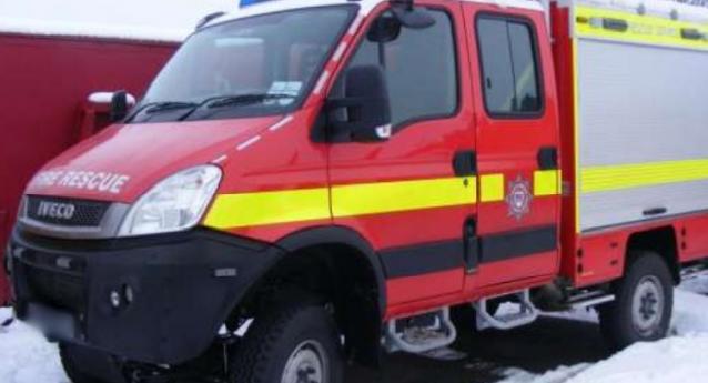 The SRT is like a van, with two doors with single steps either side to get in. The front is all red, with the Service logo on the second door. The back shows grey sliding doors for equipment. Blue sirens are visible at the front. A neon yellow line runs along the middle of the vehicle, and the top of the sliding doors.